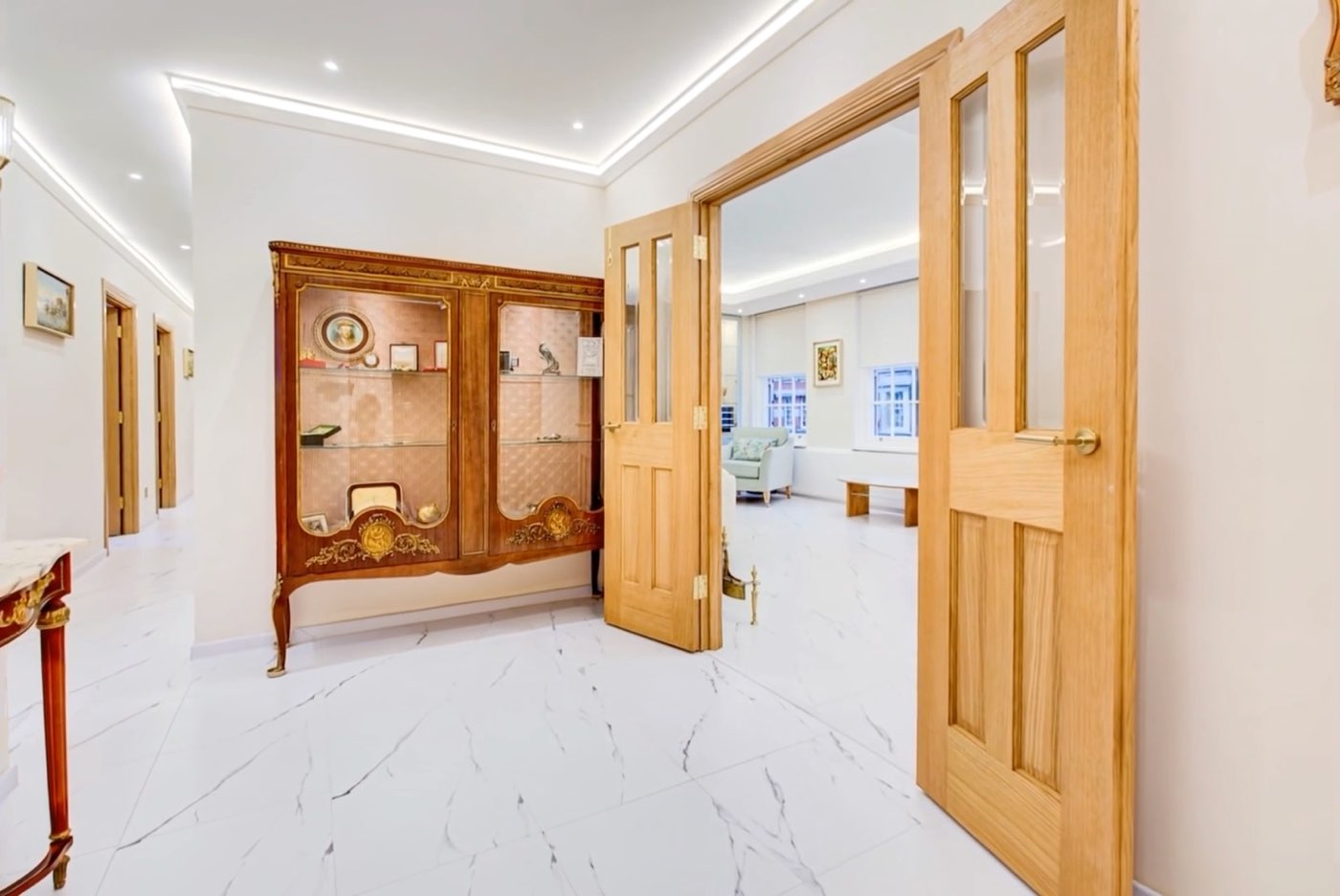 The hall of a London apartment, its doors open in a straight line through to the living room beyond.